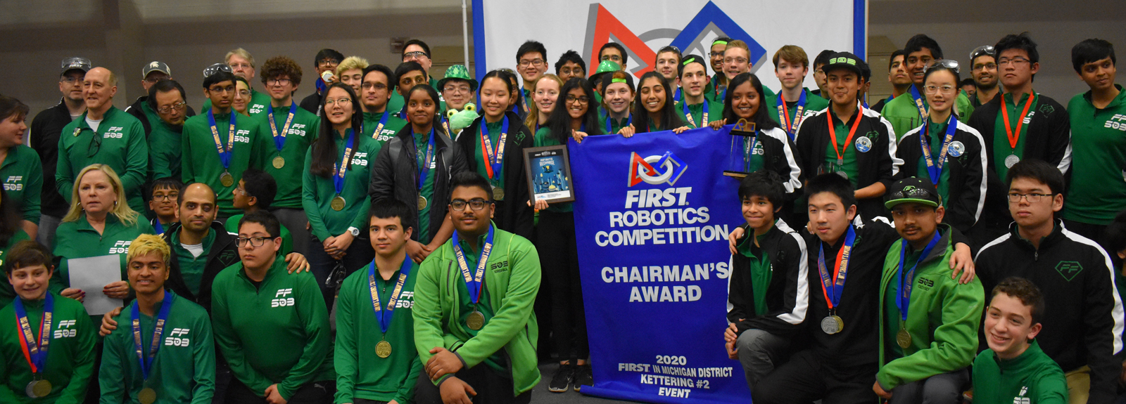Team holding Chairman's Award banner
